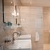 De Lunterse Boer in Lunteren bathroom with double sink, bathtub and toilet behind a glass partition