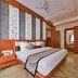 Hotel Yois in Udaipur guest room with king bed, wardrobe, wall TV and ceiling fan