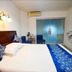 Orange Crystal Hotel Xuzhou Suning Plaza guest room with bed, blue chairs, and frosted sliding wardrobe doors.