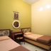 Patria Garden Hotel Blitar room with two single beds, desk, mirror, and wall lights