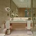 Onyx Rotana Manama bathroom with double vanity, glass shower and marble walls