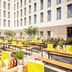 Outdoor dining terrace at Nyx Hotel Munich By Leonardo Hotels with long tables and benches in Munich