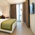 The Passage - Urban & Lifestyle Hotel Basel guest room with king bed, accent pillows and floor-to-ceiling window