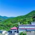 Kumano No Yado Umihikari in Kumano, set amid green mountains with a red-roofed building