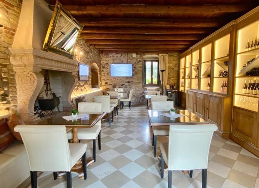 Tenuta La Presa in Caprino Veronese, rustic dining room with stone walls, wood beams and tables