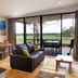 Eight Willows Retreat Metricup living area with sofa, dining table and sliding doors to patio and field views