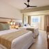 Hotel Riu Negril in Negril: bright guest room with two beds, ceiling fan, and window view
