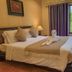 Chiang Mai Thai House bedroom with king bed, swan towel art, and window view in Chiang Mai