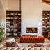 Herdade da Malhadinha Nova lounge in Beja with bookshelves, fireplace and tufted ottoman