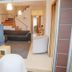 Casas e Quintas de Praia, Aveiro: bright living area with sofa, TV, stairs and sliding glass doors