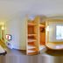 Ibis Goiania in Goiânia guest room with bed, window seat, and shelving