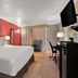 Quality Inn Wayne - Fairfield Area guest room with king bed, desk, chair and red accent wall in Wayne
