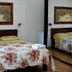 Agave Alghero bedroom with floral bedspread, wall art, and mirrored wardrobe in Alghero