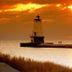 Nader's Motel & Suites in Ludington with sunset view over a lighthouse and lake breakwater