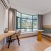 Tizi Hostel in Shanghai room with bay window seating, desk, and sofa by a large window