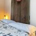 Agriturismo Rio Verde in Sasso Marconi: rustic bed with floral bedding and decorative wooden headboard