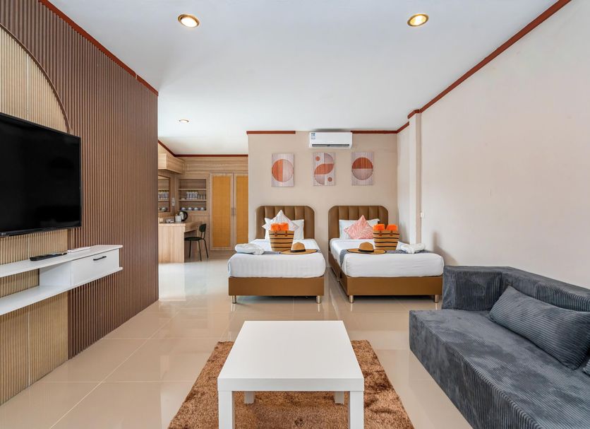 Outdoor Inn Kata Hotel in Karon: twin beds, sofa, TV and a kitchenette area in a bright room