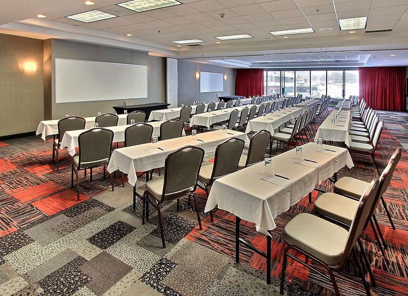 Hotel Classique in Québec City meeting room with rows of tables and chairs, projection screen and large windows