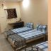 Vrp Guest House, Bhuj room with three single beds, desk, and plain cream walls
