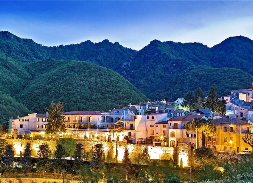 Hotel Scapolatiello in Cava de' Tirreni with illuminated hillside buildings and mountain backdrop