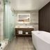 Wyndham Anaheim Hotel bathroom with glass shower, freestanding tub, vanity and mirror in Anaheim
