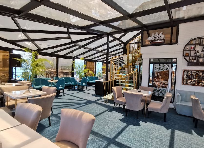 Hotel Old Town Batumi lounge with glass roof, teal seating, and modern tables