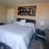 Happy Valley House Phoenix guest room with queen bed, bedside tables, mirrored closet and wall art