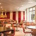 Ibis Paris Montmartre Sacré-Coeur dining area with round tables and red chairs in Paris