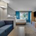 Holiday Inn Express & Suites Portland-Jantzen Beach By IHG guest room with bed, desk, sofa and window