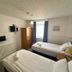 Granby Hotel, Scarborough: compact guest room with two single beds, wardrobe, TV and window with curtains