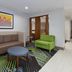 Holiday Inn Express & Suites Dayton South Franklin lobby seating area with sofa, green chair and coffee table