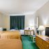 Quality Inn Rosebud Casino room in Mission with two beds, desk, lamps, and green carpet