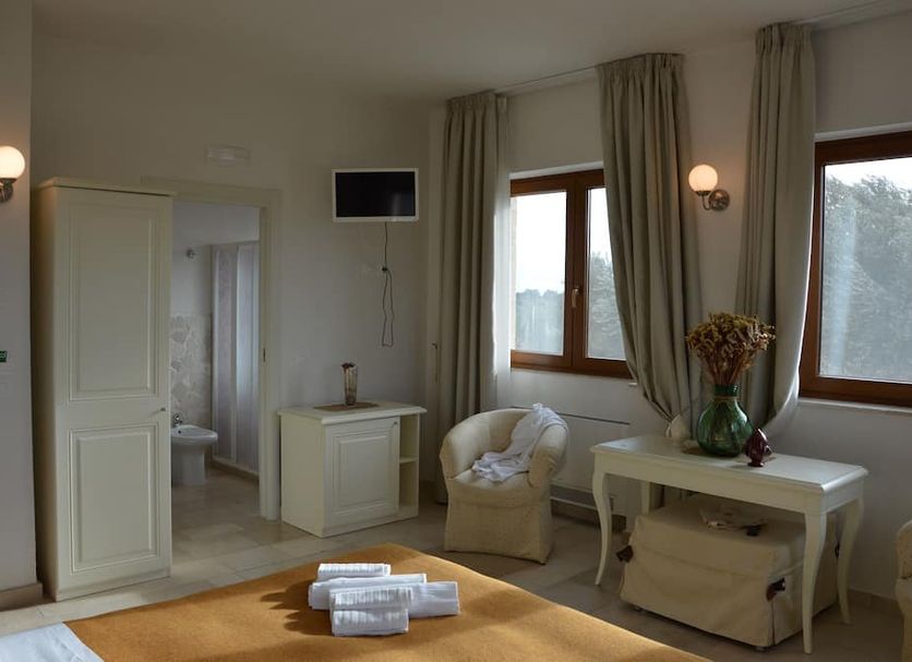 Agriturismo I Pozzetti in Fasano guest room with chair, desk, windows, and private bathroom door