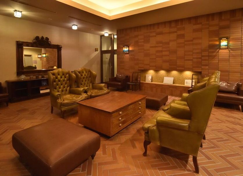 Dormy Inn Premium Otaru Natural Hot Spring lobby lounge in Otaru with tufted chairs and warm lighting