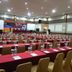 The Nagoya Plasa Redpartner in Batam conference room set with rows of tables, chairs, and stage