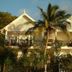 Green Roof Inn in Carriacou with tropical palm trees in front of a white two-story hotel