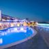 Apartamentos Sal Rossa in Sant Josep de sa Talaia with a lit outdoor pool and oceanfront terrace at night