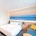 Richmond Hotel Miyazaki Ekimae guest room with bed and ocean-inspired wall art in Miyazaki