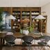 Basq House in Byron Bay dining room with wooden table, rattan chairs, bookshelves and indoor plants