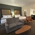 Best Western Plus Chihuahua Juventud room with two beds, sofa, chairs and kitchenette in Chihuahua