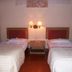 Bali Lovina Beach Cottages in Buleleng: twin beds with wall lamp and bedside table in guest room