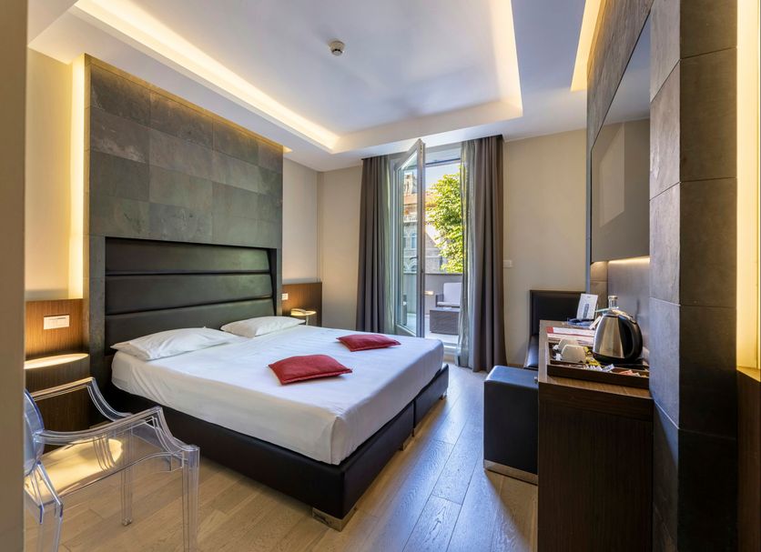 UNA Hotels Villa Dei Platani Foligno guest room with king bed, modern lighting and balcony view
