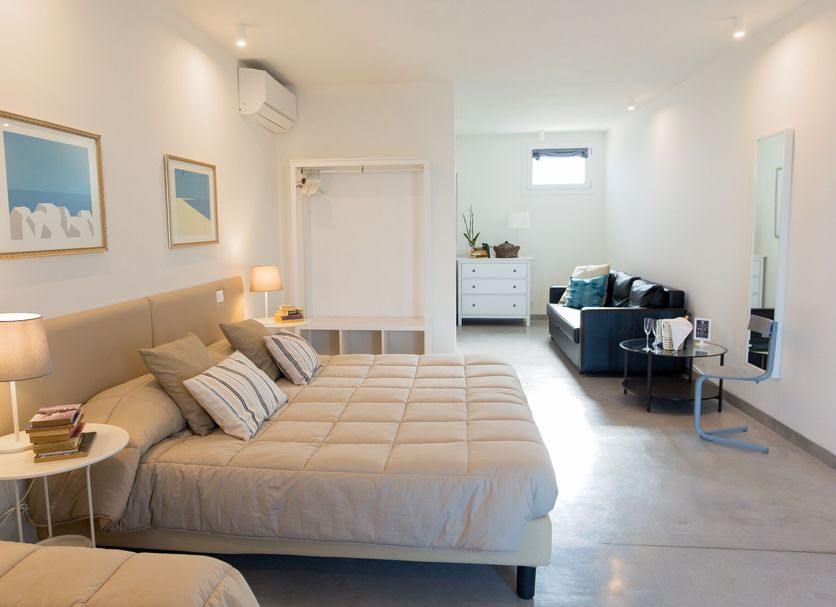 Guest House Bella Onda in Tessera: bright guest room with double bed, sofa, and white dresser