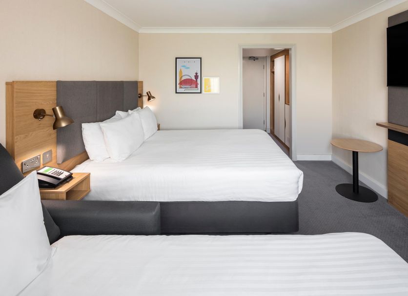 Holiday Inn London - Gatwick Airport By IHG room with two beds, wall-mounted TV and doorway to hall