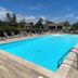 Résidence Les Cigales in Porto-Vecchio: outdoor pool with loungers, umbrellas and ladder under blue sky