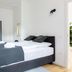 limehome Baden-Baden Bäderstraße bedroom with double bed, wardrobe and minimalist white walls