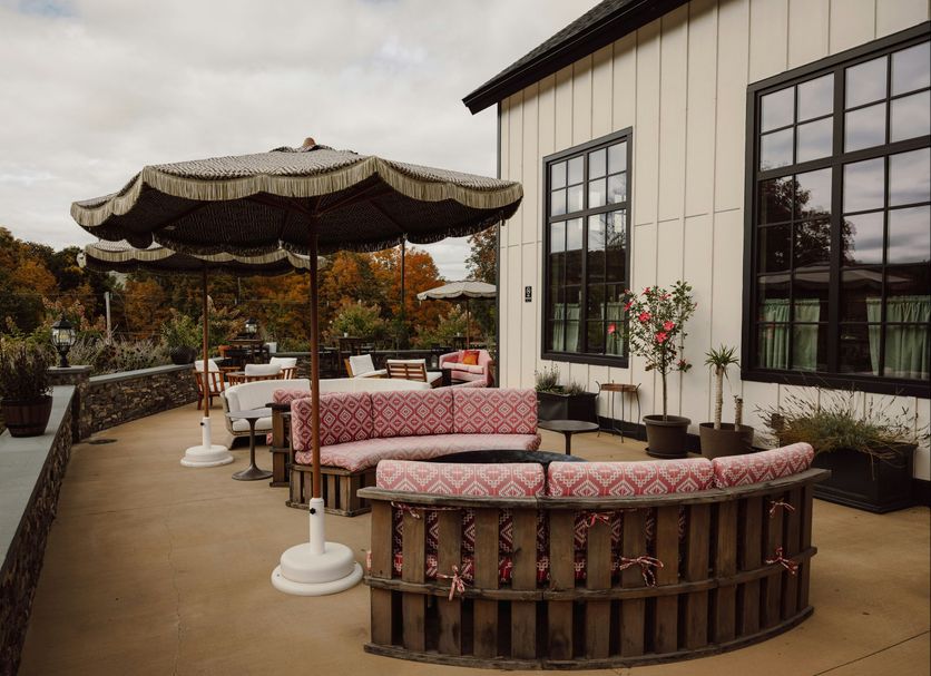 Berkshires Untold in Lenox terrace with patterned seating, umbrella shade, and hillside views