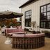 Berkshires Untold in Lenox terrace with patterned seating, umbrella shade, and hillside views