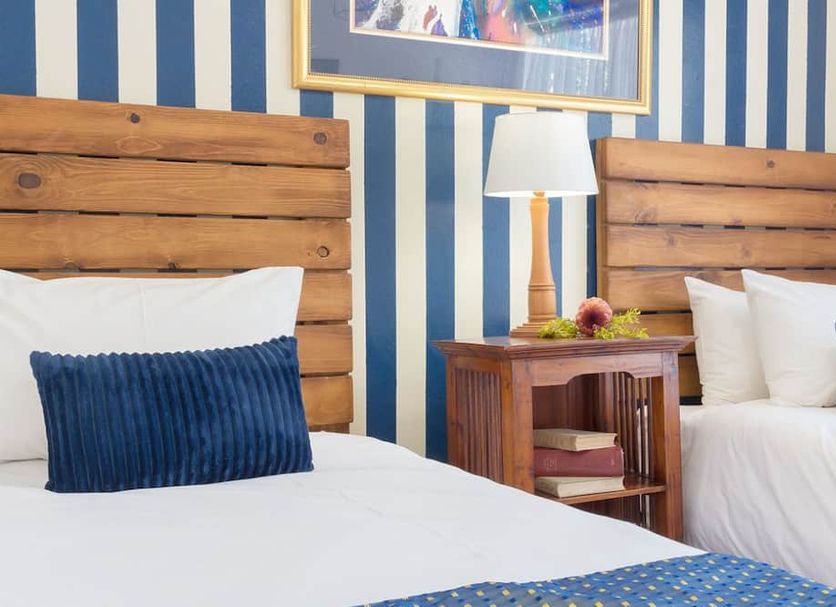 Guest House Mooigezicht, Clarens: twin beds with wooden headboards and blue striped wallpaper