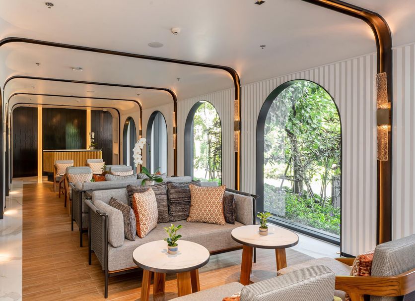 Meliá Chiang Mai lobby lounge with arched windows and cushioned seating overlooking greenery